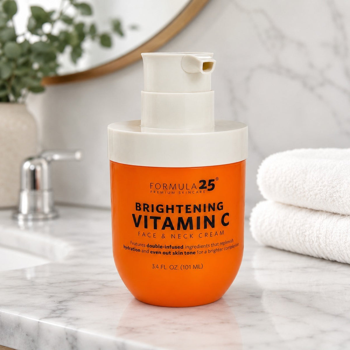 Brightening Vitamin C face and neck cream in a vibrant orange jar with a white pump top, displayed on a marble countertop beside neatly folded white towels.