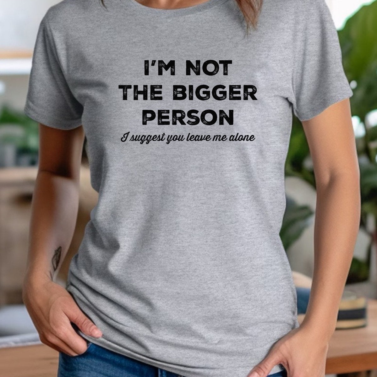 Person wearing a gray t-shirt with humorous text design.