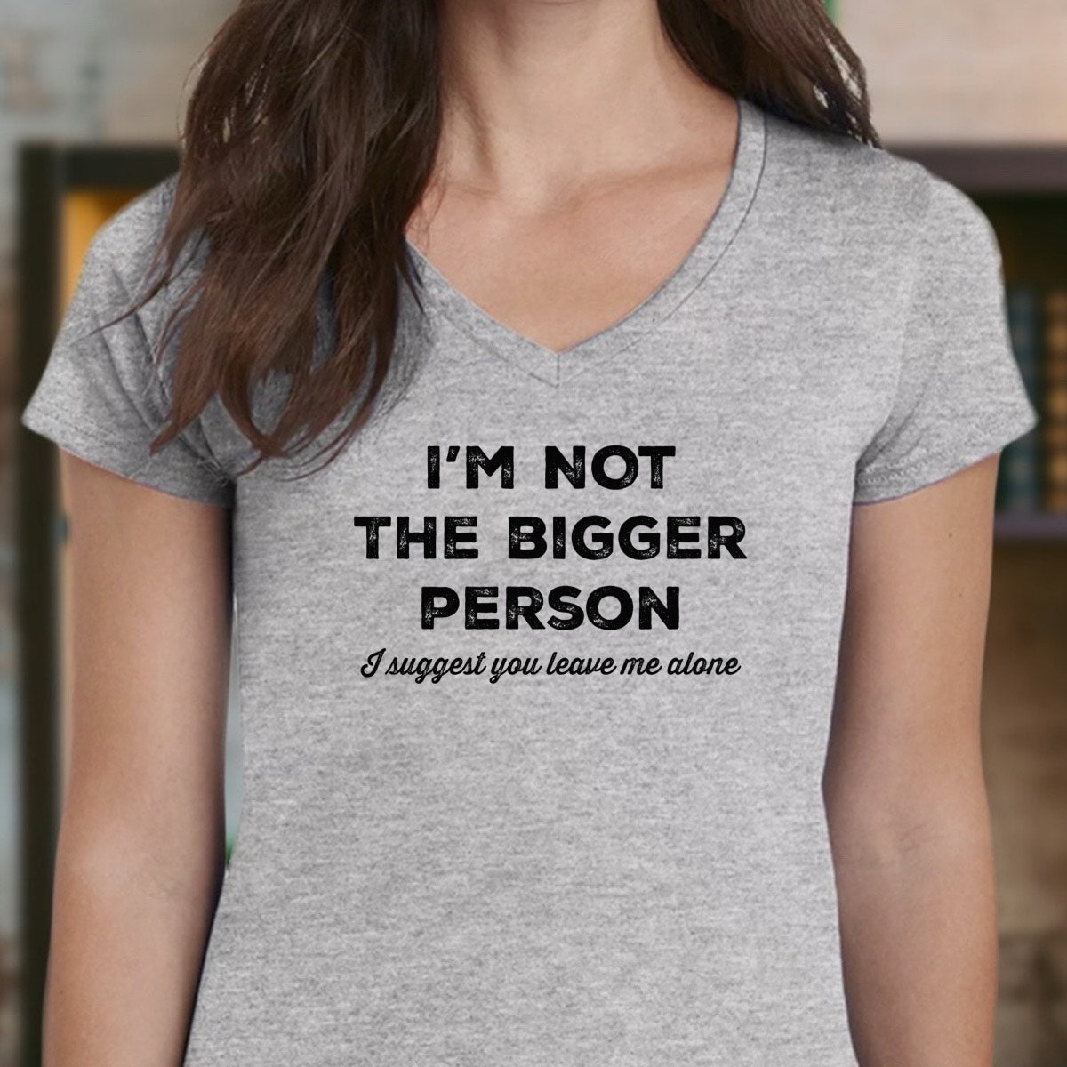 Person wearing a gray t-shirt with humorous text design.