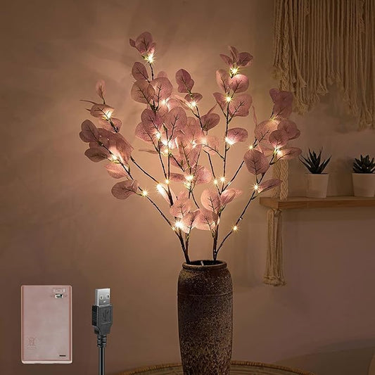 Decorative LED branch with pink leaves in a vase, USB cable, and power adapter on a neutral background.