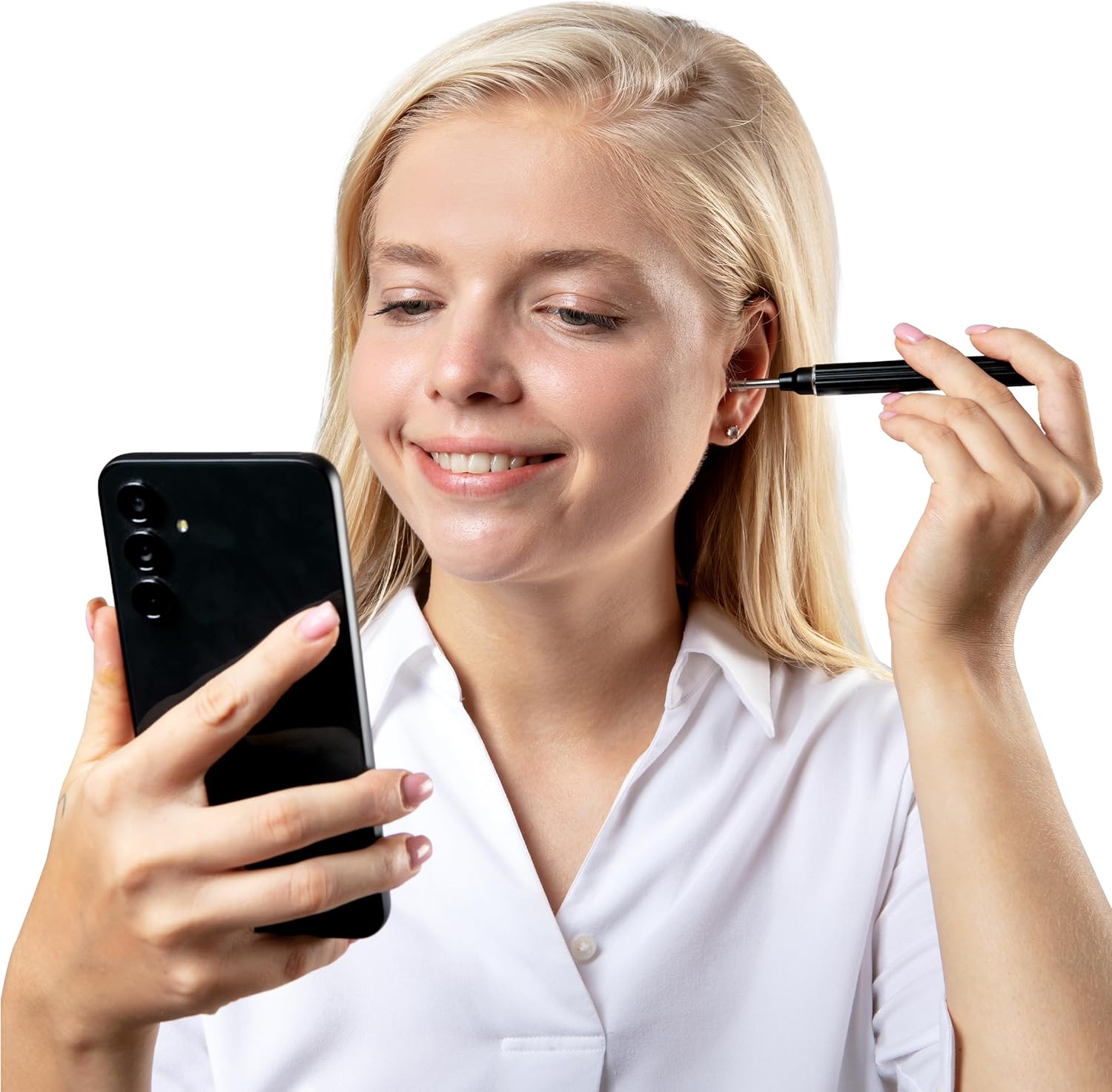 A woman with long blonde hair smiles while holding a black smartphone in one hand and an ear wax removal tool in the other, positioned near her ear. She is dressed in a white shirt, highlighting a clean, modern look.