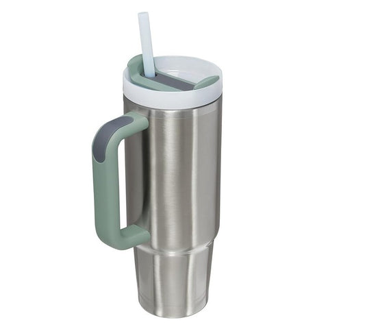 The travel mug features a sleek stainless steel body with a polished finish, a light green handle, and a white lid with a straw and cover. Its tall, tapered shape allows for easy grip and storage.
