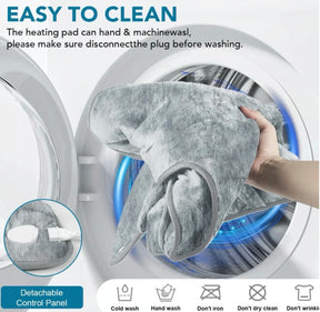 The soft gray heated neck and shoulder wrap is shown being placed into a washing machine, illustrating its easy cleaning process. A detachable control panel is visible, along with care instructions for washing methods.