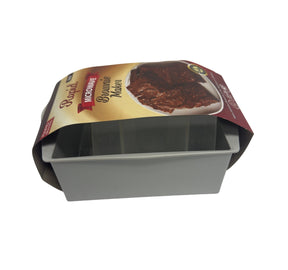 The light gray brownie maker, featuring a cardboard sleeve with colorful graphics and text, showcases a rectangular shape with an open top for easy access to baked goods. The interior includes compartments for uniform brownie preparation.