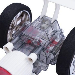 Close-up of the transparent chassis of the Atmospheric Inferno Turbo Racer, showcasing the intricate engineering with visible gears, tubes, and motor components, alongside a black rubber tire.