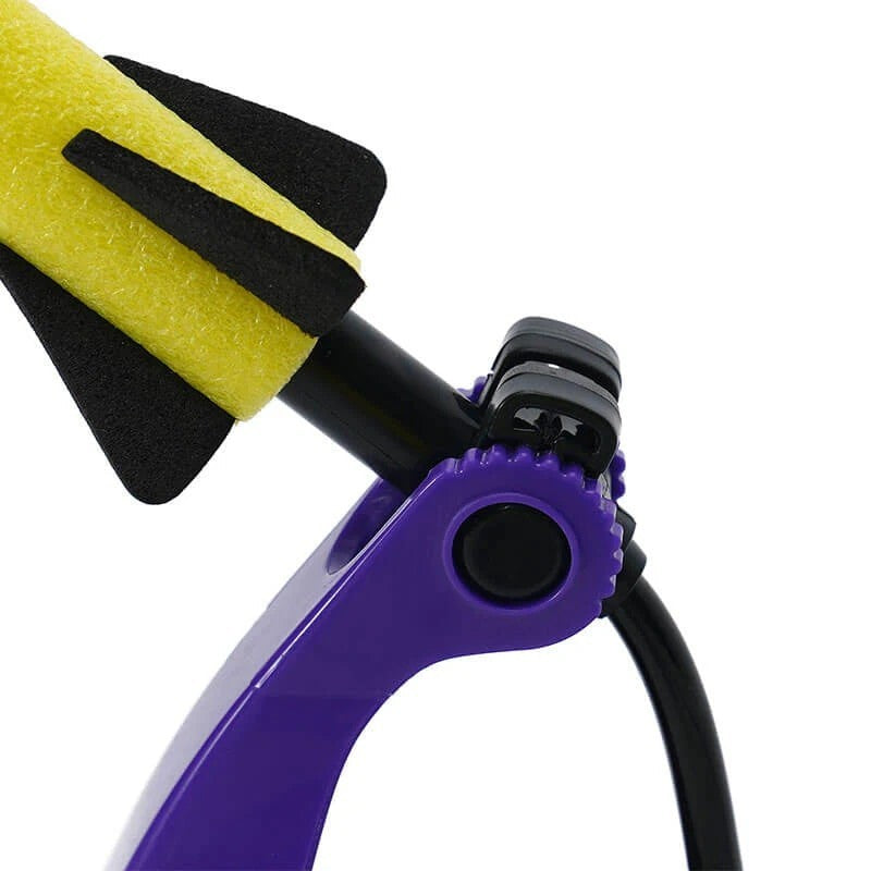 Close-up of a purple air rocket launcher featuring a yellow foam rocket with black fins positioned on a black launch tube, showcasing the lever mechanism designed for easy activation.