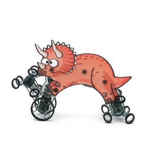 The image features a playful, cartoon-style climbing Triceratops in shades of orange with a light pink belly and exaggerated eyes, supported by black and transparent wheels for mobility. The toy is depicted in a dynamic pose, showcasing its creative design and functionality.