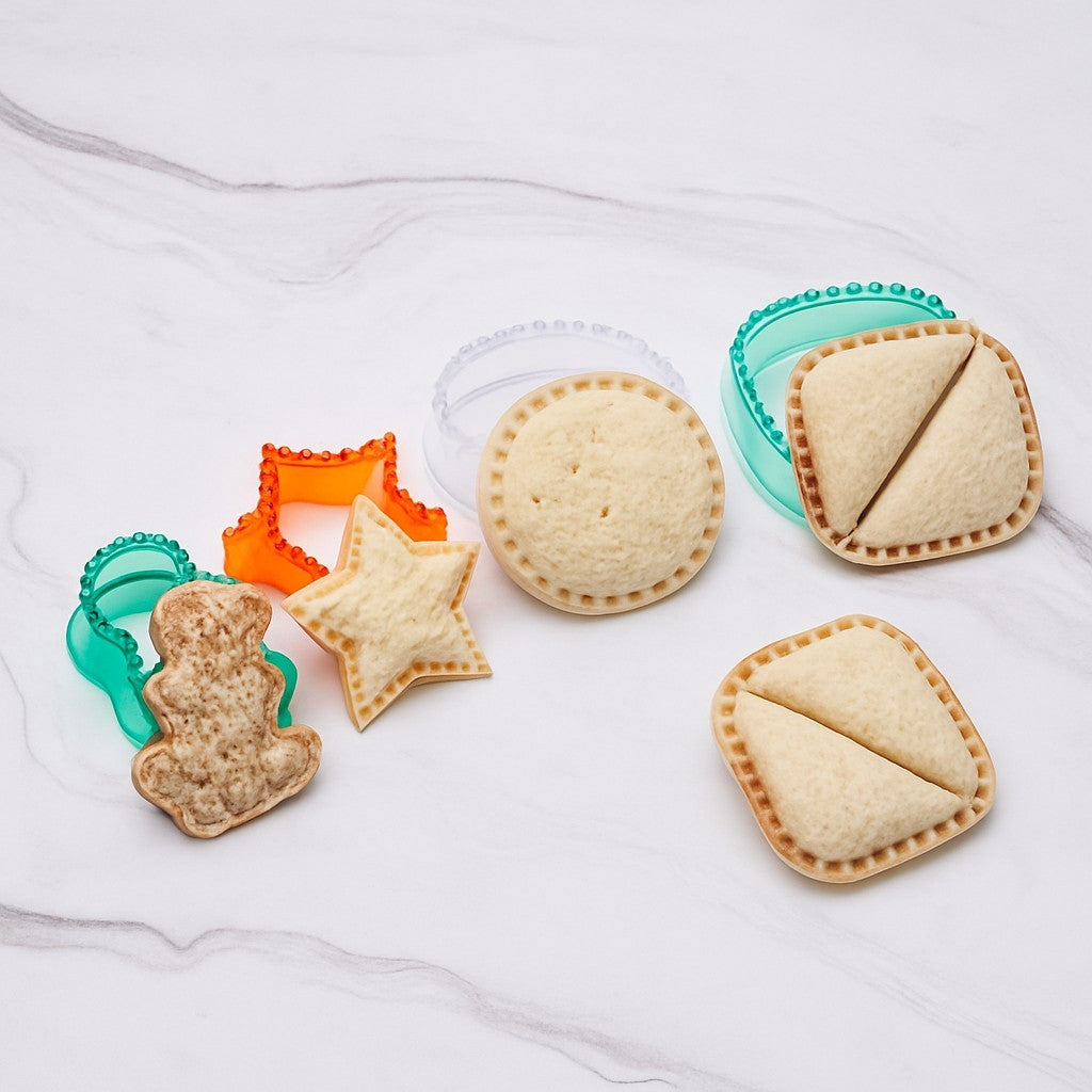 Assorted sandwich shapes include a gingerbread man, star, and a rectangular shape, alongside two sandwich seals in green and orange, with one sandwich cut in half to show the filling.