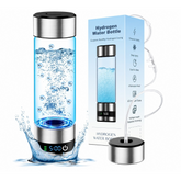 A sleek, transparent water bottle with a stainless steel lid and base, filled with bubbles and labeled "H2," is displayed alongside its packaging. The LED display at the base shows the time as "5:00," and water splashes are visible around the bottle.