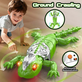 A young child interacts with a bright green remote control wall-crawling lizard toy on a smooth floor, demonstrating its ground crawling feature. The toy has glowing eyes and a shiny silver section on its back, with arrows indicating movement directions.