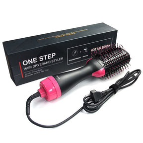 The hair dryer styler features a black body with a pink handle and bristles, showcasing a round brush head designed for styling. The product is positioned next to its sleek black packaging, which includes instructions and icons indicating its functionalities.