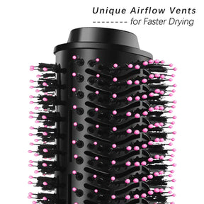 Close-up of the brush head showing unique airflow vents designed for faster drying, with a mix of black bristles and pink-tipped pins for styling.