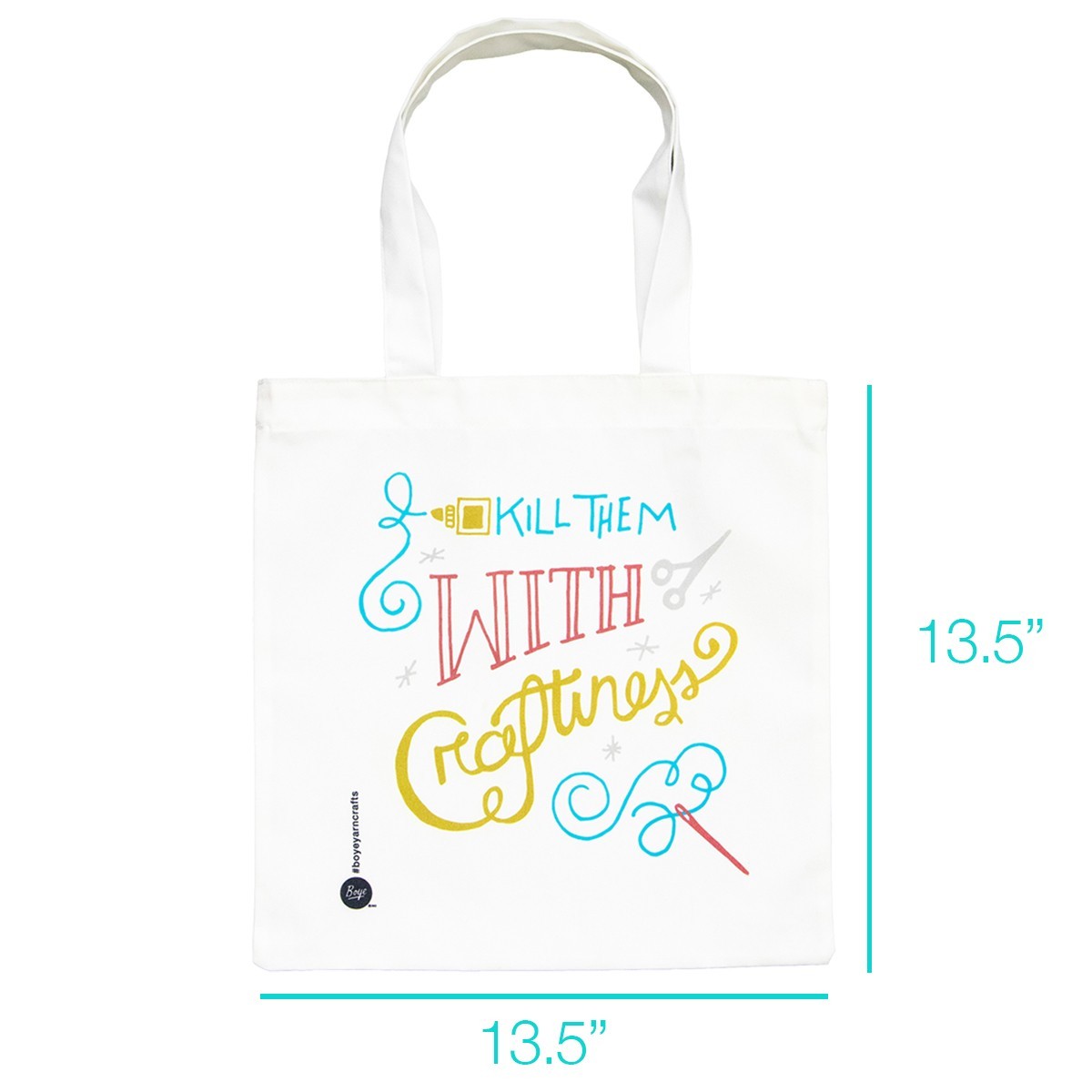 The white canvas tote bag features colorful, playful text that reads "Kill Them With Craftiness," adorned with decorative elements like a sewing needle, scissors, and swirls. It has two sturdy handles for easy carrying.