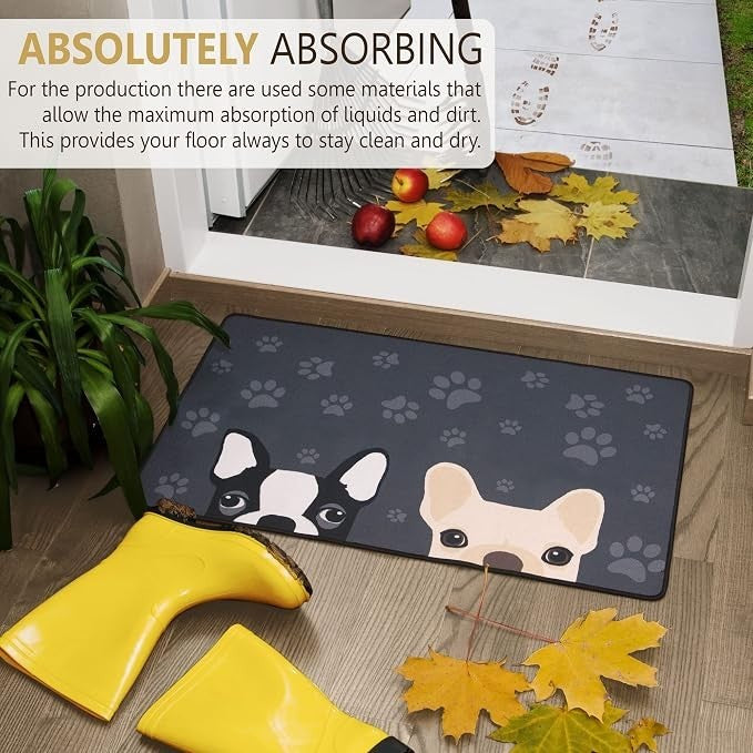 Doormat featuring illustrations of a black and white pug and a light tan pug against a dark grey background, surrounded by paw prints. Yellow rubber boots and autumn leaves are placed nearby, with a glimpse of a door entrance in the background.