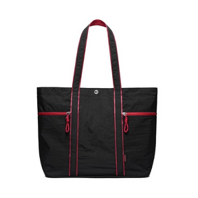 Spacious black canvas tote bag featuring bright red zippers and stitching, dual shoulder straps, and a sturdy design suitable for heavy-duty use. Two front zippered pockets add functionality and style.