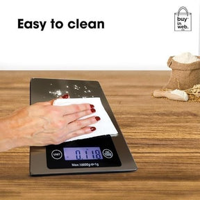 A hand with manicured nails is wiping the stainless steel surface of the digital food scale, which displays a measurement of 0.118. A burlap sack filled with flour is partially visible in the background, along with a wooden countertop.