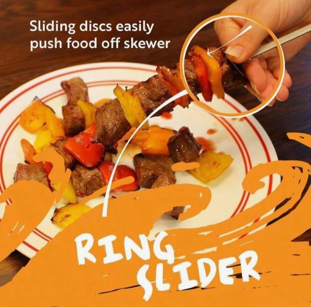 A hand holds a sliding disc tool to push grilled beef and colorful vegetables off a stainless steel skewer onto a white plate, with ketchup drizzled on the food. The image features text highlighting the "Ring Slider" feature.