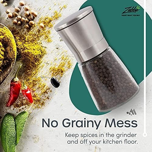 Stainless steel and glass salt and pepper grinder shown with peppercorns inside, set against a colorful backdrop of spices, herbs, and chili peppers. Text highlights "No Grainy Mess" and emphasizes keeping spices contained.