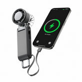 Compact black handheld fan with a digital display showing battery percentage, connected to a smartphone via a charging cable, illustrating its dual function as a fan and power bank.