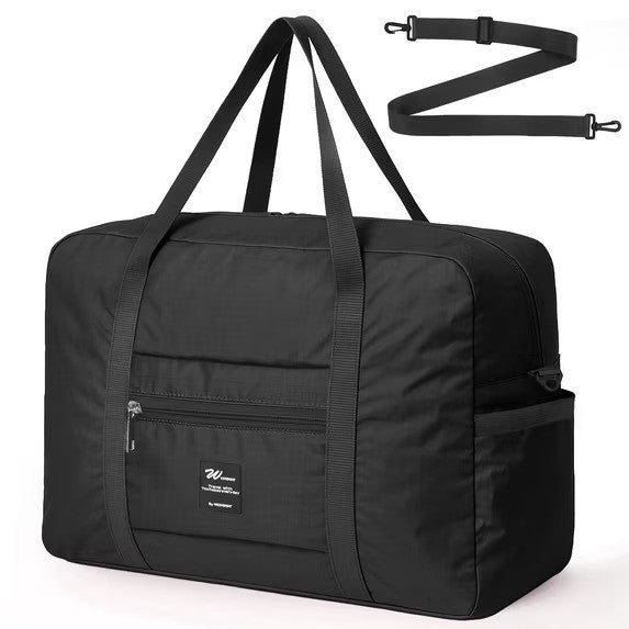 Stylish black foldable tote bag with dual handles, featuring a front zip pocket and a removable shoulder strap. Ideal for travel, it combines practicality with a sleek design.