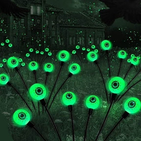 Bright green LED eyeball lights on dark stems, creating a spooky effect against an eerie background. The set features multiple glowing eyeballs, ideal for Halloween decor.