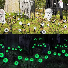 The image shows the Solar Halloween Scary Eyeball Lights displayed in two settings: one in daylight with white eyeballs and the other at night glowing green. The lights are set among Halloween decorations, with a ghostly figure visible in the background.