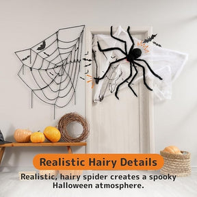A large, hairy black spider with glowing red eyes is positioned on a door, adjacent to a black web and small bats, creating a spooky Halloween decor. Nearby, a wooden table displays several pumpkins and a decorative basket.