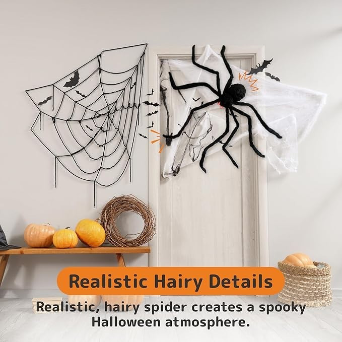 A large, hairy black spider with glowing red eyes is positioned on a door, adjacent to a black web and small bats, creating a spooky Halloween decor. Nearby, a wooden table displays several pumpkins and a decorative basket.