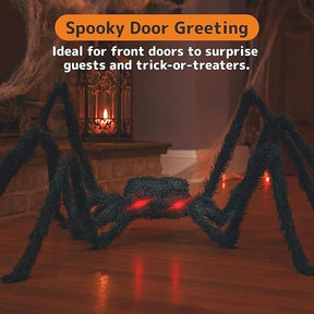 A large, hairy spider with glowing red eyes is positioned on a wooden floor, surrounded by a festive Halloween setting featuring candles and cobwebs. The spider's eight legs are spread wide, creating a spooky appearance suitable for greeting guests at a front door.