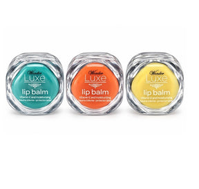 Three jars of Wonder Luxe Lip Balm displayed in a row, featuring teal, orange, and yellow balms, each with a glossy, round container and a label indicating "lip balm" along with "Vitamin E and moisturizing."