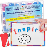 A transparent container holds colorful magnetic letters in red and blue, with a double-sided magnetic board featuring the word "Inspire" and a smiling face drawn on it, alongside a red eraser and black marker.