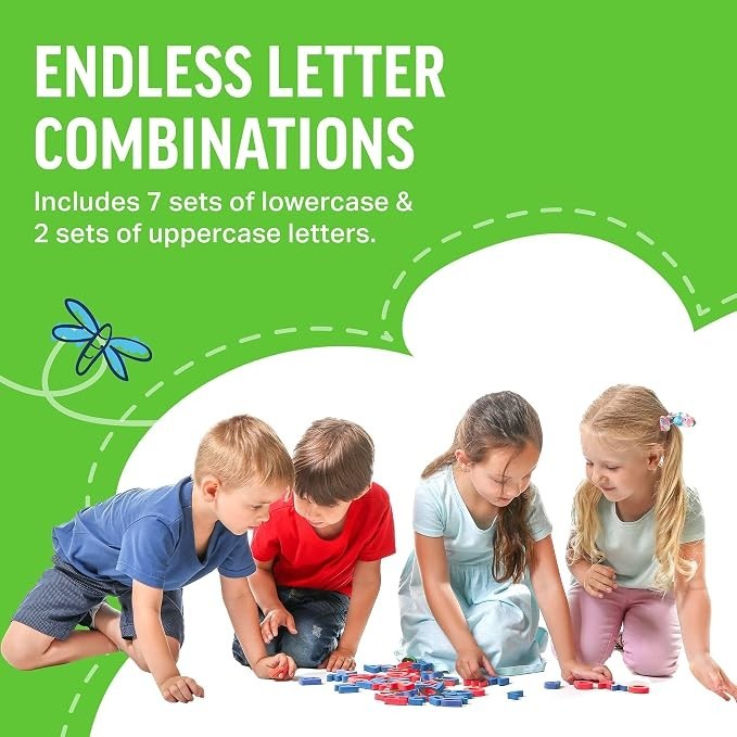 Four children are gathered on the floor, engaged in play with colorful magnetic letters scattered around them. They are focused intently on arranging the letters, with two boys dressed in blue and red shirts, and two girls wearing light-colored tops.