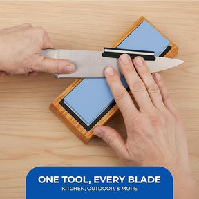 A knife is being sharpened with the Sharp Pebble Whetstone on a bamboo base, showcasing the light blue 1000/6000 grit stones positioned to enhance the sharpening process. The image features a hand holding the knife while another hand adjusts the blade's angle against the whetstone.