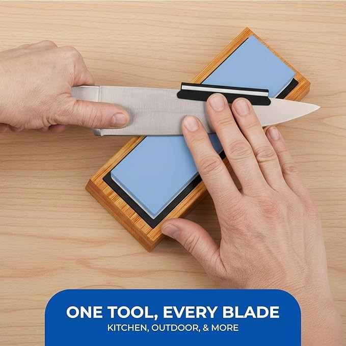 A knife is being sharpened with the Sharp Pebble Whetstone on a bamboo base, showcasing the light blue 1000/6000 grit stones positioned to enhance the sharpening process. The image features a hand holding the knife while another hand adjusts the blade's angle against the whetstone.