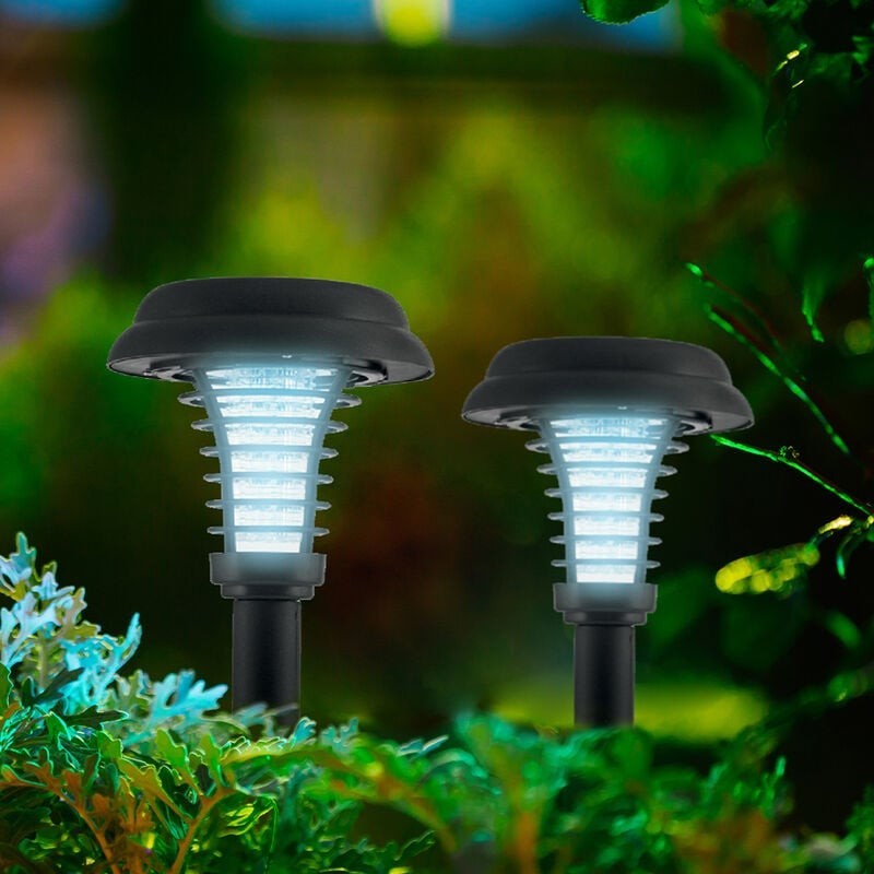 Two solar-powered bug zapper stakes with a sleek black design and translucent blue lighting, surrounded by lush greenery. The stakes feature a curved top and striped patterns, designed for outdoor use.