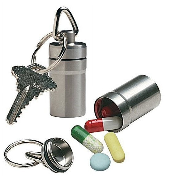 Metal keychain pill box with a shiny silver finish, featuring a key ring attachment, partially opened to reveal a red and white capsule inside along with several multicolored pills shown next to it.