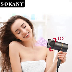 A woman with long, flowing hair smiles while holding the SOKANY SK-2202 hair dryer, which features a concentrator nozzle and is shown emitting airflow in a 360-degree direction. The background includes soft, blurred bathroom elements, emphasizing the product in use.