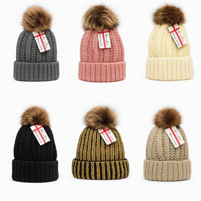 Variety of Women's winter pom pom beanie hats displayed in six different colors: dark gray, pink, cream, black, olive green striped, and light beige, each featuring a fluffy pom pom on top and a cozy knit design.