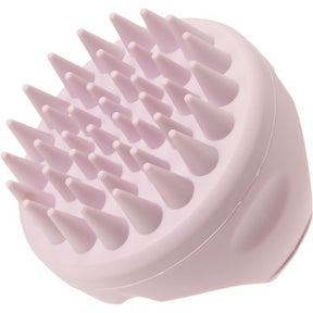 The scalp massager features a rounded design with multiple soft, pointed bristles arranged on top, all in a light lavender color for gentle stimulation. The ergonomic shape allows for comfortable handling during use.
