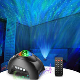 A black star projector with a multi-colored light display projects onto a ceiling, creating a swirling night sky effect in shades of blue and green. A remote control is positioned next to the projector on a surface, with musical notes illustrated around it.